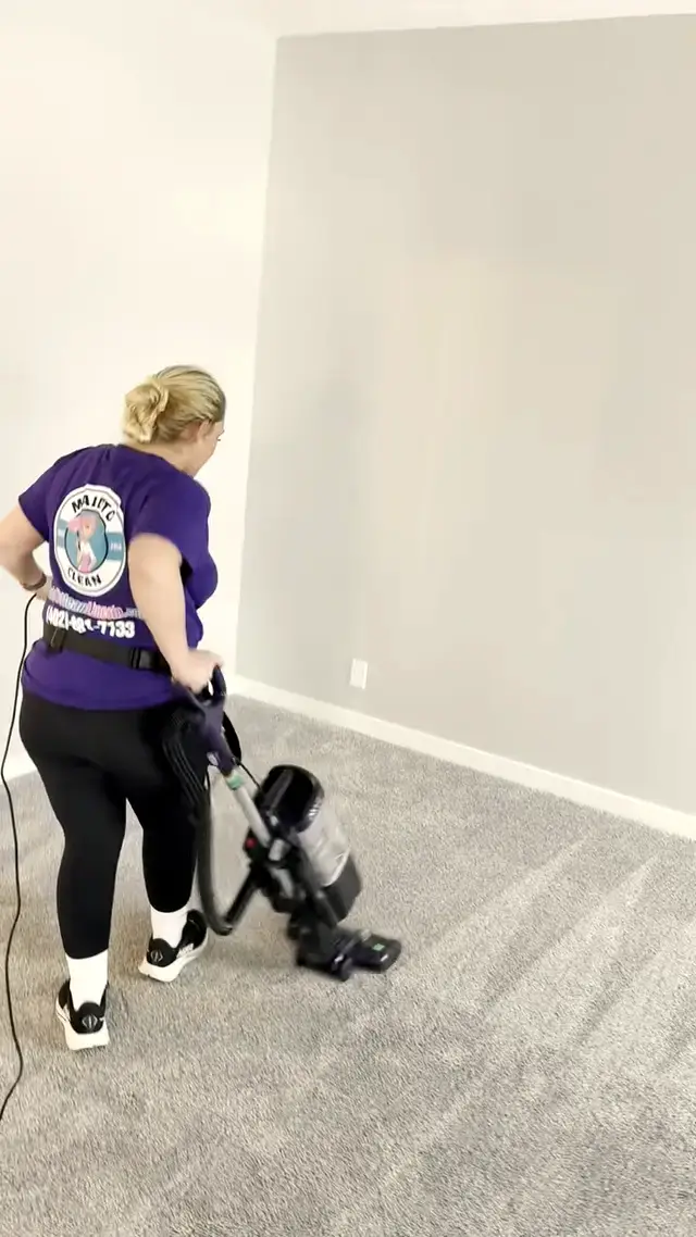 Melanie vacuuming the carpet in an empty bedroom